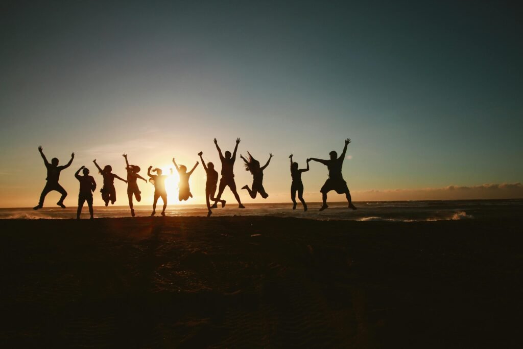 pexels-photo-1000445-1000445 Silhouette of a group of friends jumping on a beach at sunset, expressing joy and freedom.