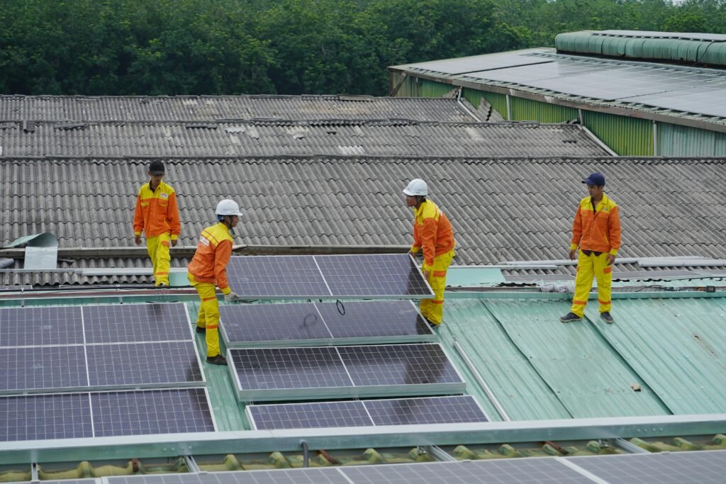pexels-photo-11645008-11645008 Workers installing solar panels on a roof for sustainable energy solutions.